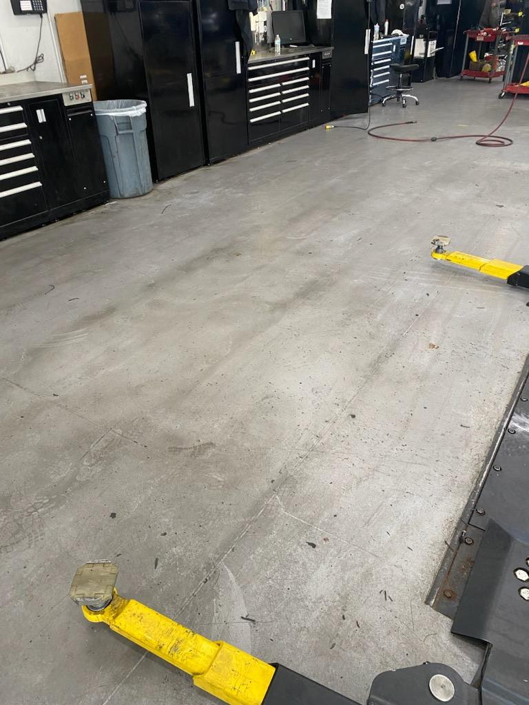 Oil-stained auto shop floor before cleaning