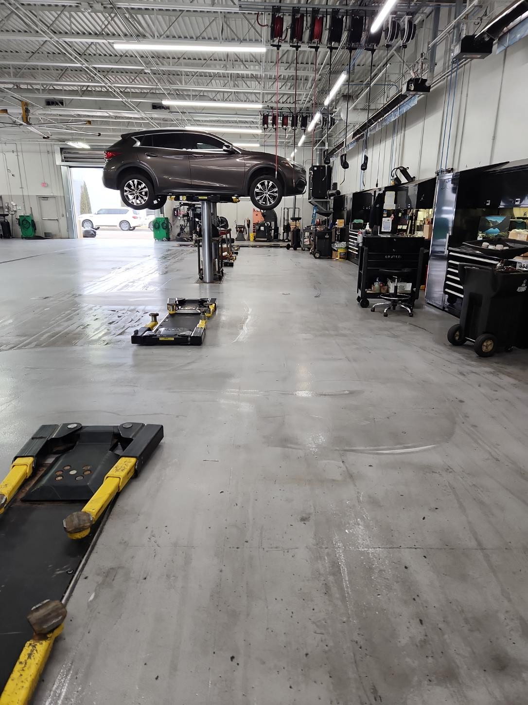 Technician actively cleaning the auto bay floor